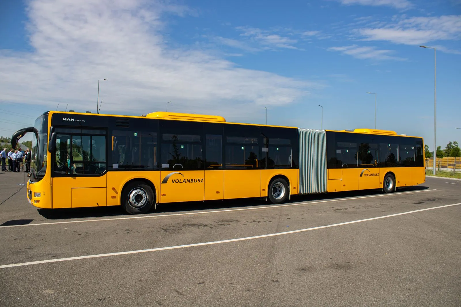 Un autobus snodato giallo, visto di lato, in un piazzale