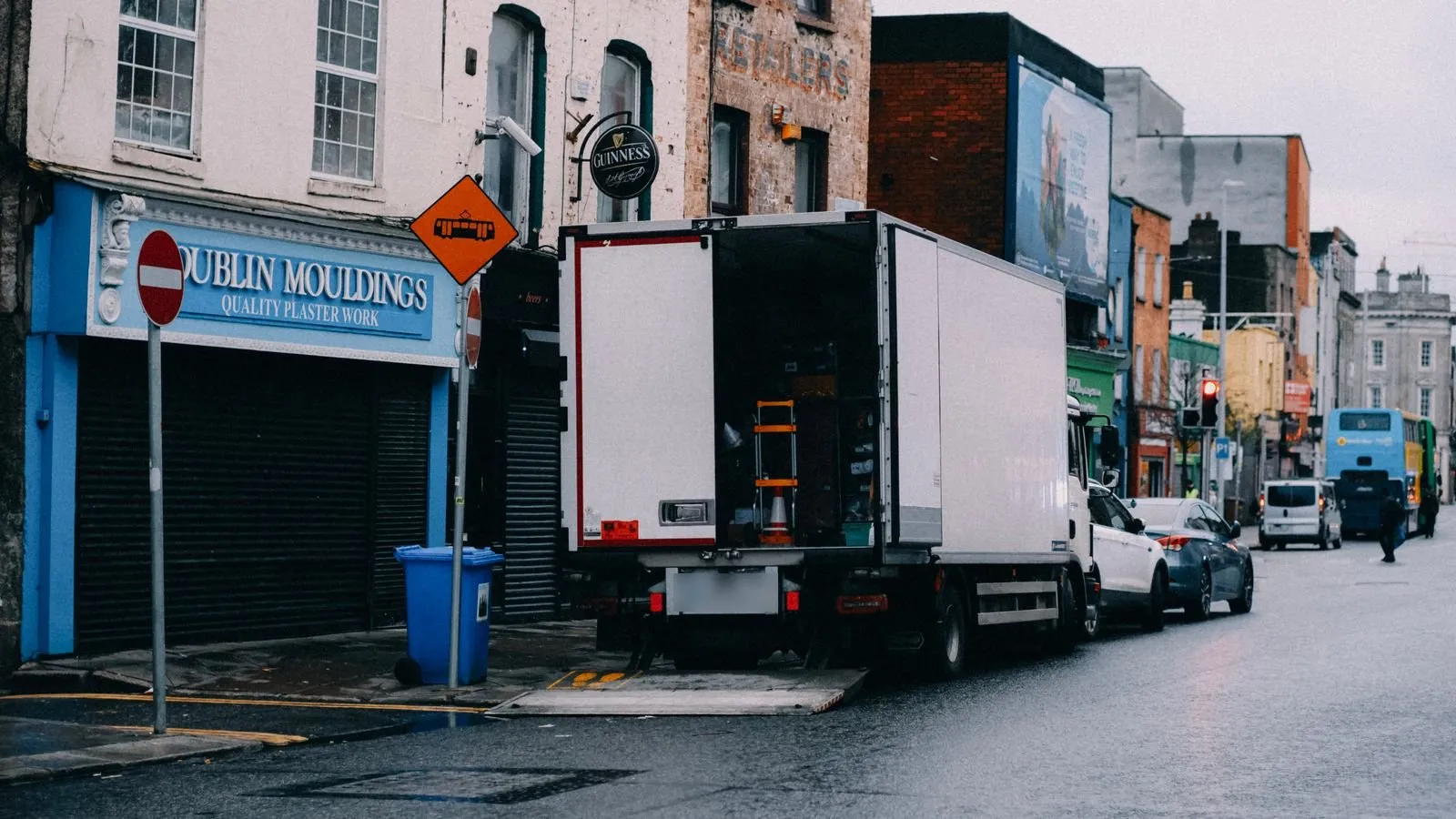 Un camion furgonato bianco che scarica in una via di città