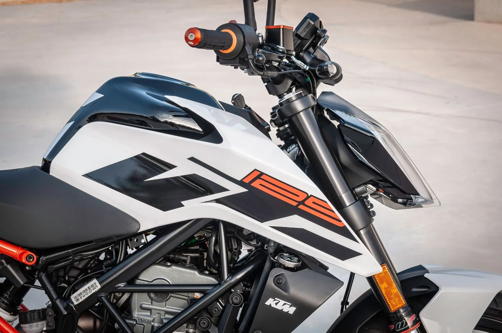Il serbatoio di una moto bianca e nera con la scritta 125